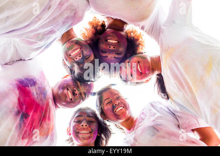 Low angle view of smiling friends covered in pigment powder Stock Photo