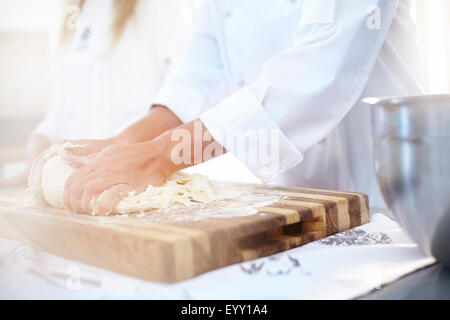 Chef kneading dough on cutting board baking in kitchen Stock Photo