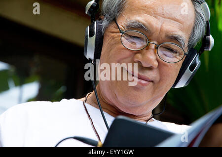 Senior man enjoying music on his tablet Stock Photo