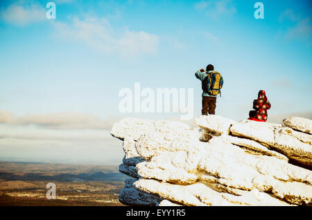Caucasian hikers admiring scenic view from mountaintop Stock Photo