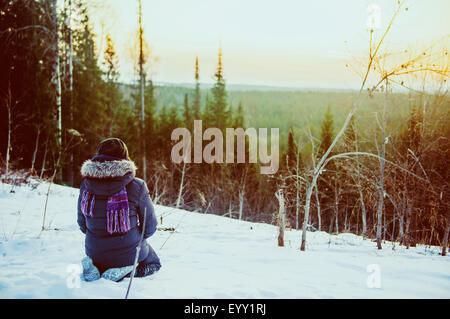 Caucasian hiker admiring scenic view from snowy hillside Stock Photo
