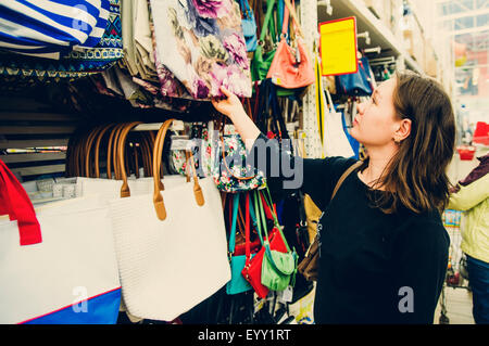 Caucasian woman shopping for purse in store Stock Photo