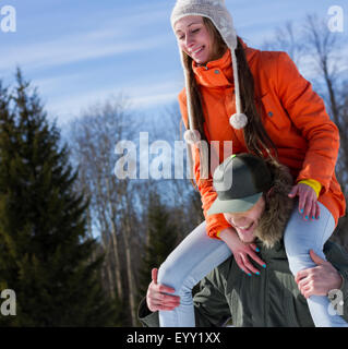 Caucasian man carrying girlfriend on shoulders Stock Photo