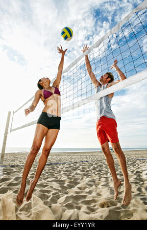 Friends playing volleyball on beach Stock Photo