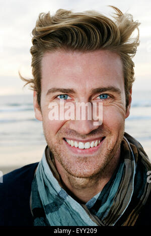 Caucasian man smiling on beach Stock Photo