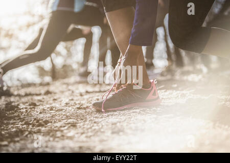 Close up of athlete tying shoe Stock Photo