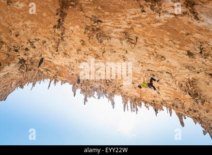 Caucasian climber scaling rock wall Stock Photo