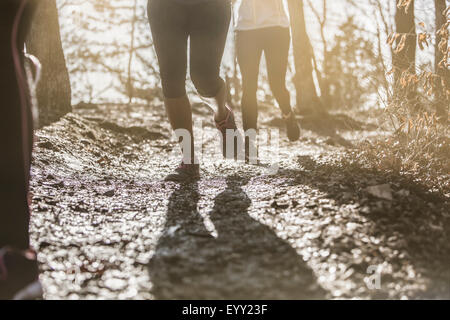 Runners jogging on dirt path Stock Photo