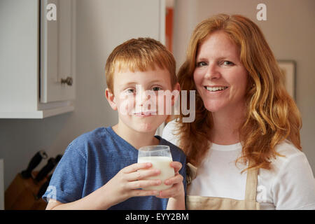 Caucasian mother and son drinking milk in kitchen Stock Photo