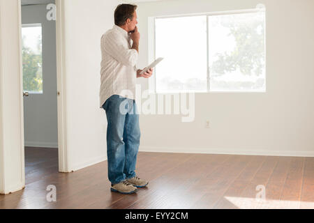 Caucasian man using digital tablet in empty room Stock Photo