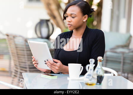 Mixed race businesswoman using digital tablet at outdoor cafe Stock Photo