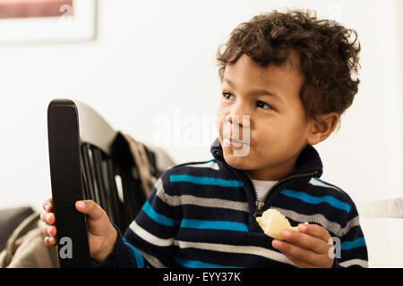 Mixed race boy eating at counter Stock Photo