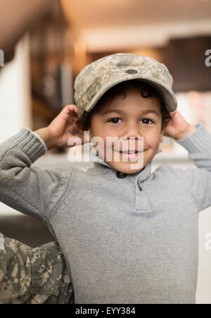 Mixed race boy wearing soldier cap Stock Photo