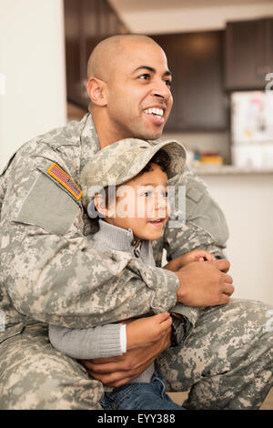 Mixed race soldier father hugging son Stock Photo
