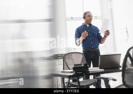 Black businessman talking on headset in office Stock Photo
