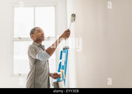 Man painting interior wall of new house. Redecoration, renovation ...