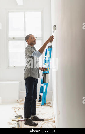 Black man painting wall of home Stock Photo