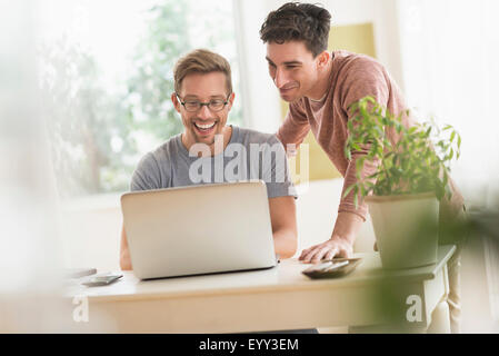 Caucasian gay couple using laptop Stock Photo