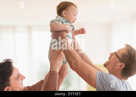 Caucasian gay fathers holding baby Stock Photo