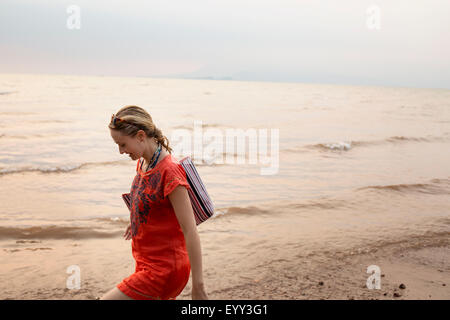 Caucasian woman walking on beach Stock Photo