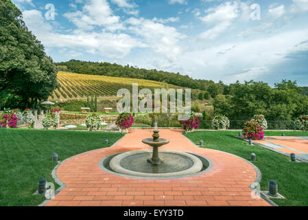 Fountain and walkway in landscaped grounds over rural fields, Radda in Chianti, Siena, Italy Stock Photo