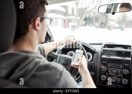 Caucasian man using cell phone and driving car Stock Photo