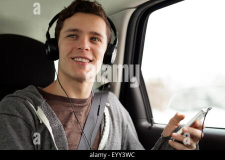 Caucasian man listening to mp3 player in car Stock Photo