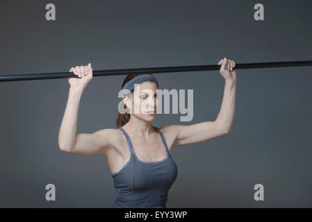 Mixed race woman lifting weights Stock Photo