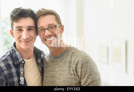 Caucasian gay couple smiling in home Stock Photo