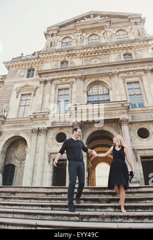Caucasian couple walking on ornate building steps, Paris, Ile-de-France, France Stock Photo