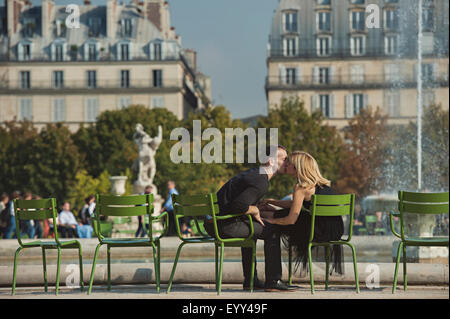 Caucasian couple kissing near fountain in urban park, Paris, Ile-de-France, France Stock Photo