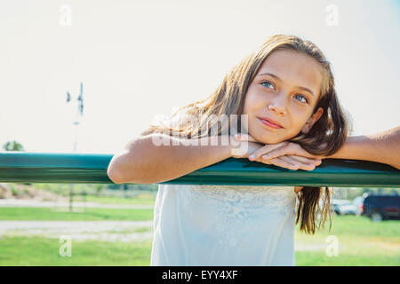 Caucasian girl leaning on farm fence Stock Photo