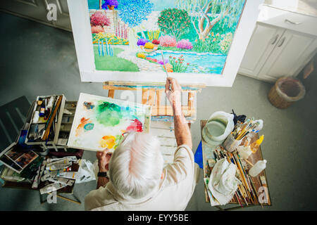 Caucasian artist painting in studio Stock Photo