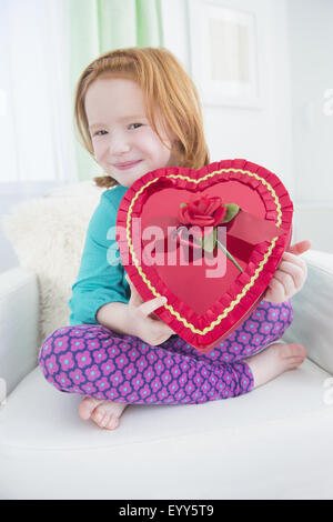 Caucasian girl holding gift box of candy Stock Photo