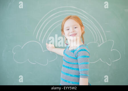 Caucasian girl drawing on chalkboard Stock Photo