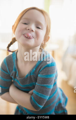 Defiant Caucasian girl sticking out tongue Stock Photo