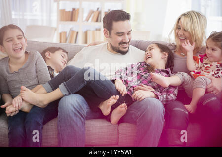 Caucasian family playing on sofa Stock Photo
