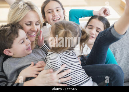 Caucasian mother and children playing on sofa Stock Photo