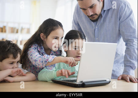 Caucasian father and children using laptop Stock Photo