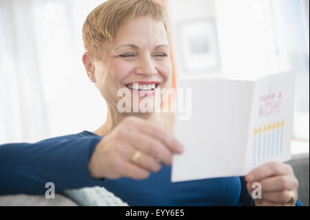 Caucasian woman reading birthday card Stock Photo