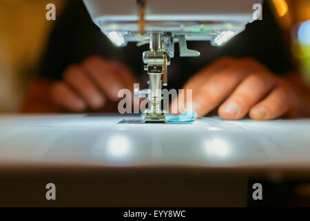 Close up of Caucasian dressmaker using sewing machine Stock Photo