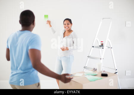 Couple painting room in new home Stock Photo