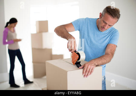 Man taping cardboard box to move Stock Photo