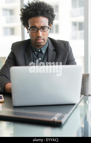 Hispanic businessman using laptop in office Stock Photo