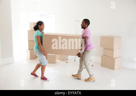 Couple carrying cardboard box in new home Stock Photo