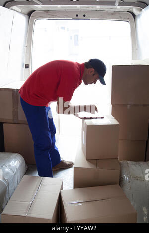 Caucasian delivery man using digital tablet in van Stock Photo