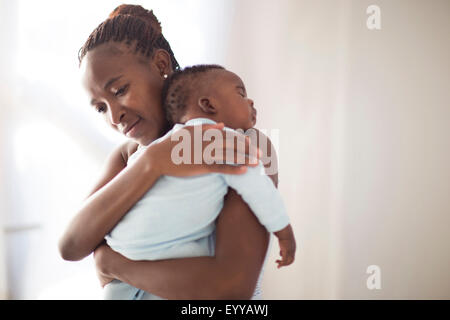 Black mother holding sleeping baby Stock Photo