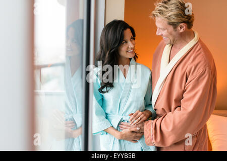 Man rubbing belly of pregnant wife in bedroom Stock Photo