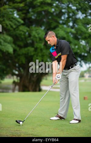 Caucasian man teeing off on golf course Stock Photo