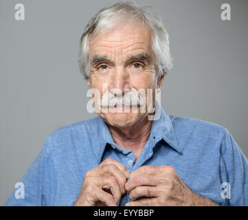 Close up of older Caucasian man buttoning his shirt Stock Photo